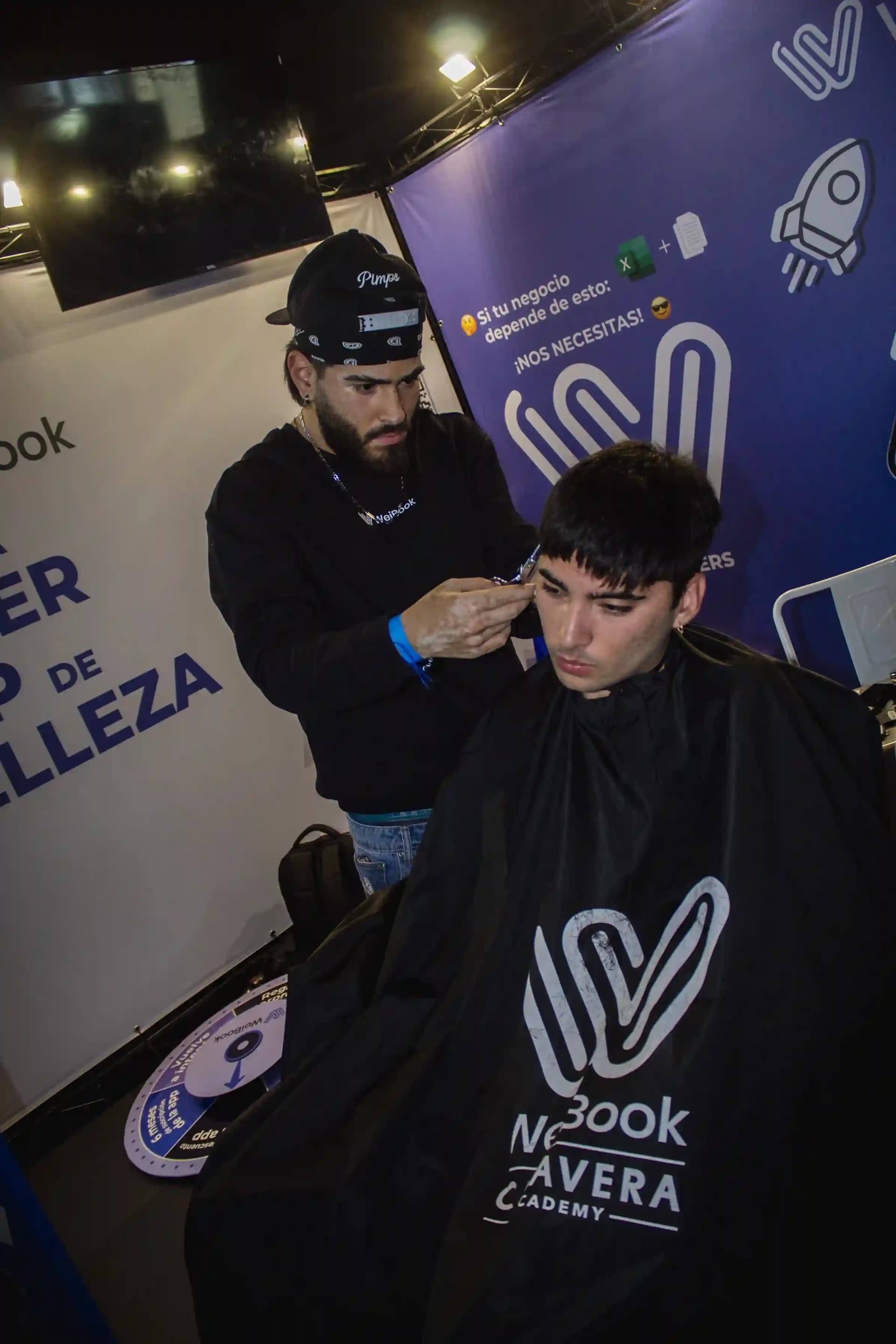 Barbero haciendo un corte en el stand de WeiBook en la feria de belleza de Bogotá, Colombia