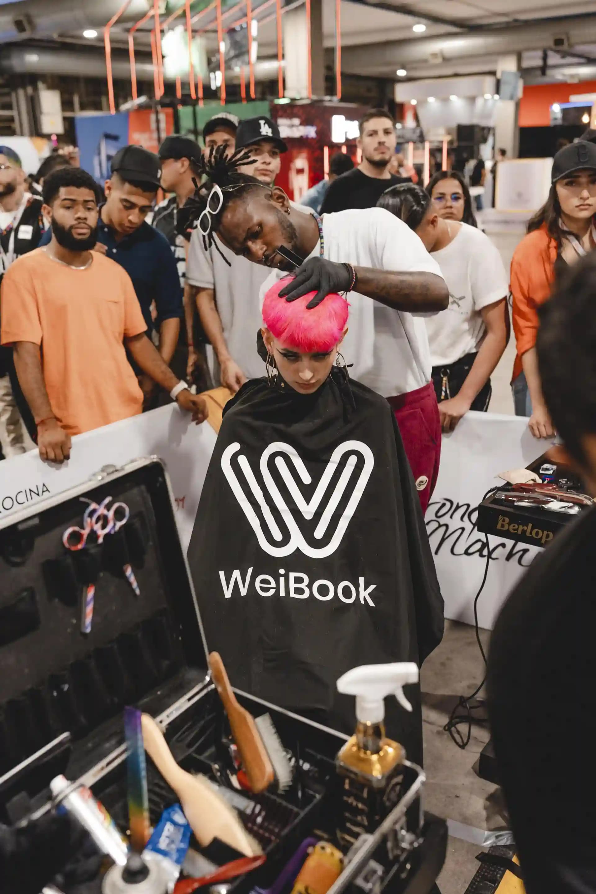 Barbero compitiendo en un concurso de corte en vivo en la feria de barberías de Medellín, Colombia