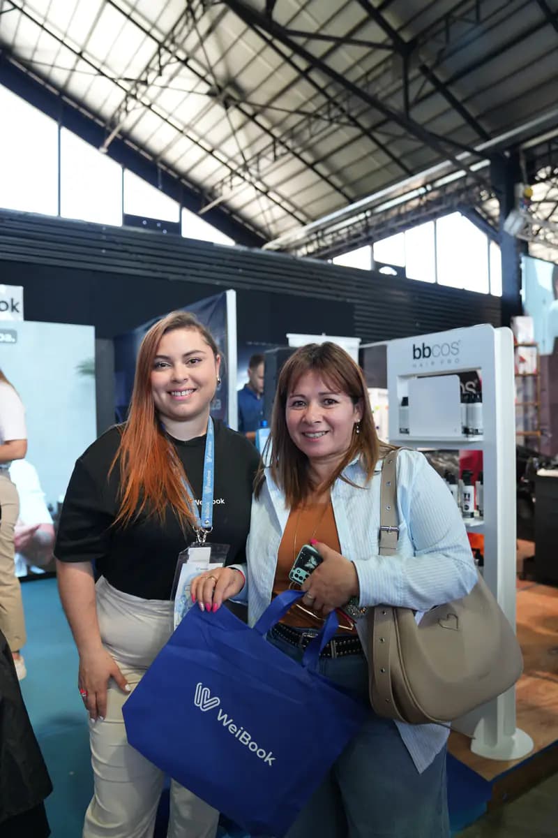 Asesora y clienta posan con una bolsa de WeiBook en Argentina