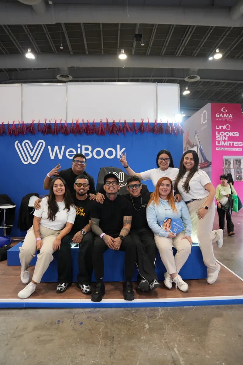 Equipo y clientes posan en el stand de WeiBook en México